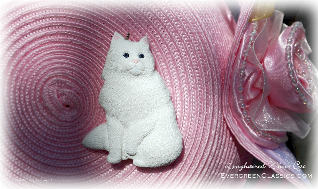 White cat on woven pink hat with flower.